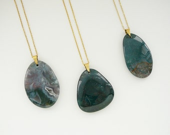 May include: Three gold chain necklaces with green and grey agate stone pendants. The pendants are all different shapes and sizes.