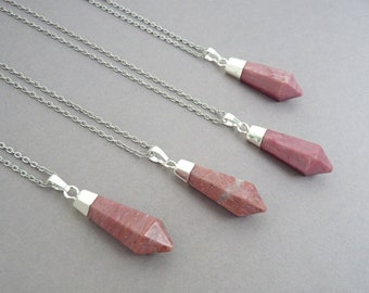 May include: Four silver chain necklaces with pink and white gemstone pendants in the shape of a point.