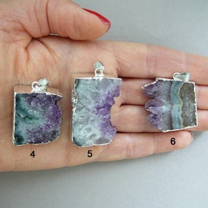 Pode incluir: Tr&ecirc;s pingentes de cristal de ametista bruta com bordas e argolas de metal prateado. Cada pingente apresenta uma forma irregular &uacute;nica com estruturas cristalinas roxas e brancas. Os pingentes est&atilde;o marcados com os n&uacute;meros 4, 5 e 6.