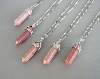 May include: Five silver chain necklaces with pink and white crystal point pendants. Each pendant has a silver cap at the top.