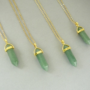 May include: Four necklaces featuring light green, hexagonal, pointed stone pendants suspended from thin gold-toned metal chains. Each pendant is secured by a gold-toned metal cap at the top, connecting the stone to the delicate link chain.