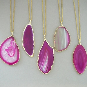May include: Five gold chain necklaces with pink and white agate pendant charms. The pendants are all different shapes and sizes.