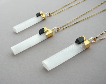 May include: Three gold necklaces with white selenite crystal pendants and black tourmaline accents. The pendants are topped with gold leaf.