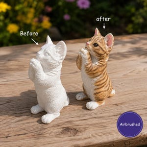 May include: Two cat figurines in a standing, praying pose. The left figurine is plain white, labelled "Before". The right figurine is painted with brown and tan tabby stripes, labelled "after" and "Airbrushed". Both have textured fur details.
