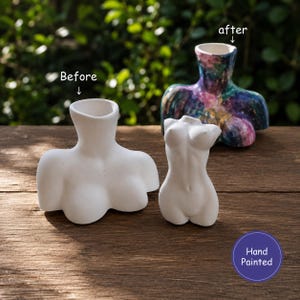 May include: Two white ceramic torso vases, one labelled Before and one labelled after, with a third torso vase in the background featuring a multicoloured galaxy paint finish. A purple circular badge with the text Hand Painted is visible.