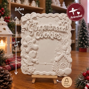 May include: A white rectangular plaque with scalloped edges, featuring the embossed text "Gingerbread Cookies" and relief decorations of gingerbread figures, a house, and snowflakes. It measures 20.5 cm tall and rests on a small wooden stand.