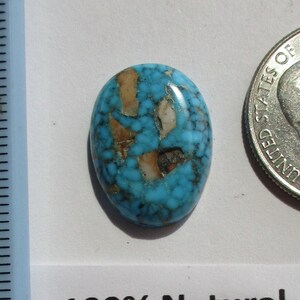 May include: A turquoise cabochon with a red web pattern, labeled "100% Natural, High Grade Kingman Red Web HP-33-KRW 13.7ct."