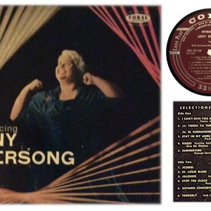 Puede incluir: Una portada de álbum de vinilo vintage con una mujer cantando con un micrófono. El álbum se titula "Introducing Leny Eversong" y es una publicación de Coral Records. La portada del álbum es negra con un diseño rojo y blanco.