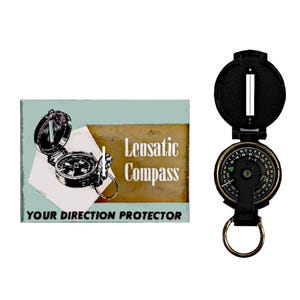 Puede incluir: Una brújula negra y dorada con un anillo, junto a un letrero vintage. El letrero dice "Lensatic Compass" y "Your Direction Protector" en texto blanco sobre un fondo azul y marrón.