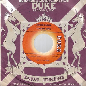 Pode incluir: Disco de vinil vintage de Junior Parker intitulado "Yonders Wall" no selo Duke Records. O disco apresenta um rótulo laranja e branco. A capa é roxa com ilustrações de unicórnios e o texto "Royal Fidelity".