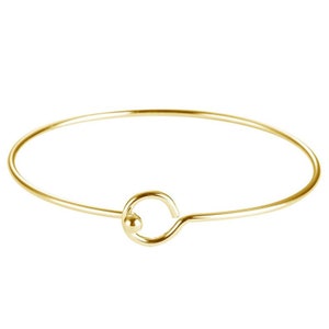 Op de afbeelding: Een eenvoudige gouden armband met een ronde sluiting.