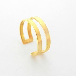 Peut inclure: Une bague à double bande dorée avec une finition brossée.