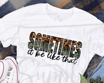 May include: White t-shirt with a green, orange, and black graphic print that says "Sometimes it be like that".