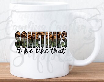 May include: White ceramic mug with a black and green camouflage pattern that says "SOMETIMES it be like that" in white text.