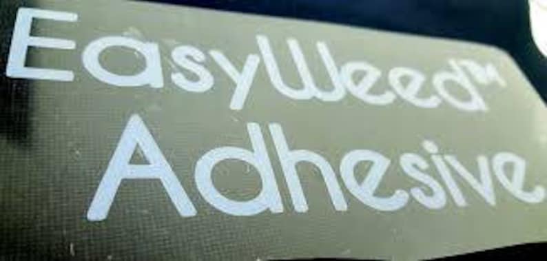 May include: White vinyl lettering on a clear background reads "EasyWeed" and "Adhesive".