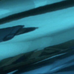 May include: A roll of teal metallic vinyl with a reflective surface.