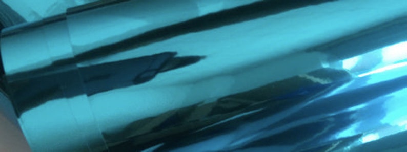 May include: A roll of teal metallic vinyl with a reflective surface.