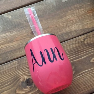 May include: Pink stainless steel wine tumbler with a black vinyl decal that says "Ann".