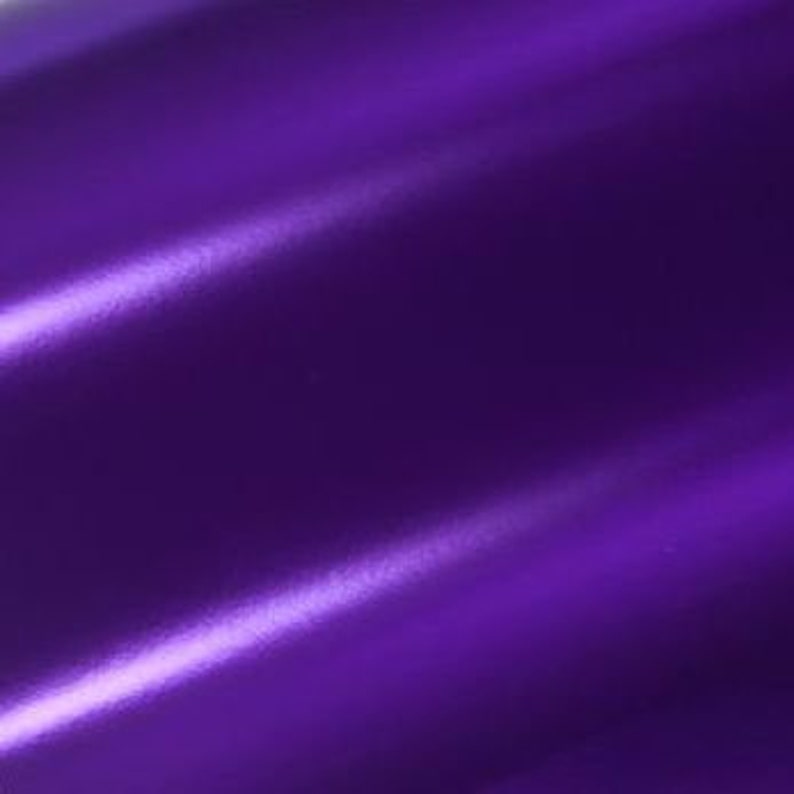 May include: A smooth, deep purple fabric with a subtle sheen. The fabric has a slight texture and is folded in a way that creates a wave-like pattern.