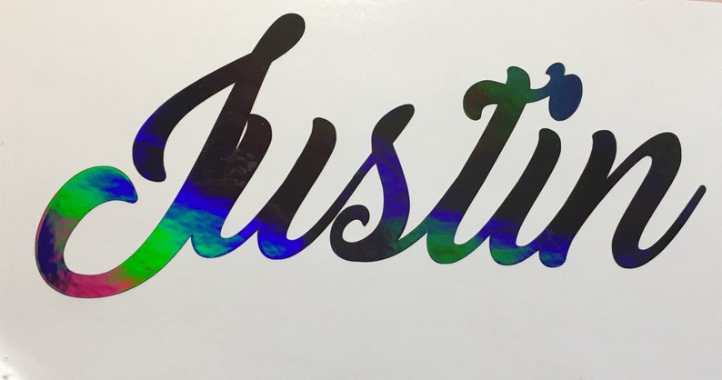 May include: A black vinyl decal with the name "Justin" written in a cursive font. The decal has a holographic finish that shimmers with rainbow colors.