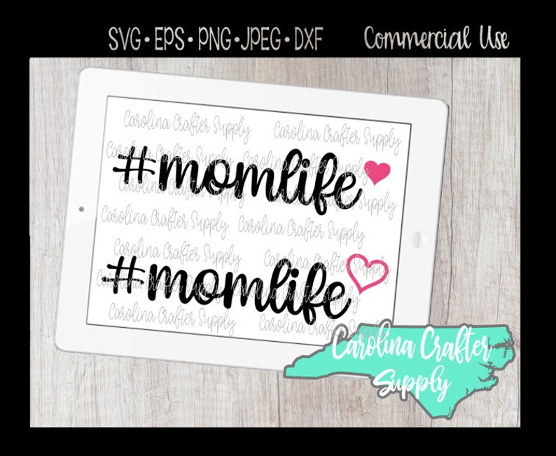 May include: A digital design featuring the text "#momlife" in black with a pink heart. The design is displayed on a white tablet with a blue and green outline of the state of North Carolina and the text "Carolina Crafter Supply".