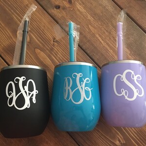 May include: Three stainless steel tumblers with personalized monograms and matching straws. The tumblers are black, teal blue, and lavender.