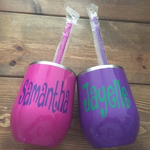 May include: Two stainless steel tumblers with personalized names, "Samantha" and "Jayelle", in purple and pink with matching straws.