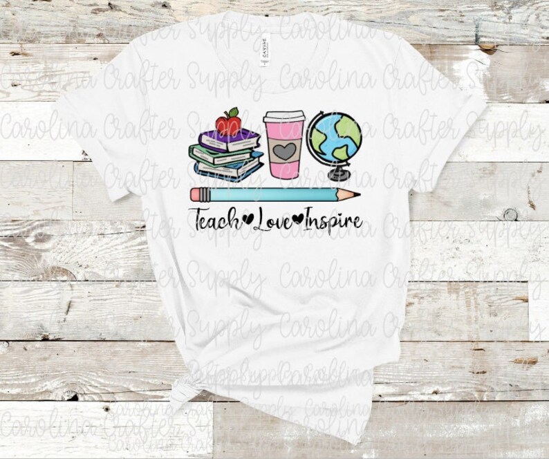 May include: White t-shirt with a design of a stack of books, a coffee cup, a globe, a pencil, and the text "Teach Love Inspire".