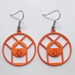 May include: A pair of orange earrings with a geometric design. The earrings are made of a thin, wire-like material and feature a circle with a smaller circle inside. The smaller circle has the Greek letters Phi and Psi inside.