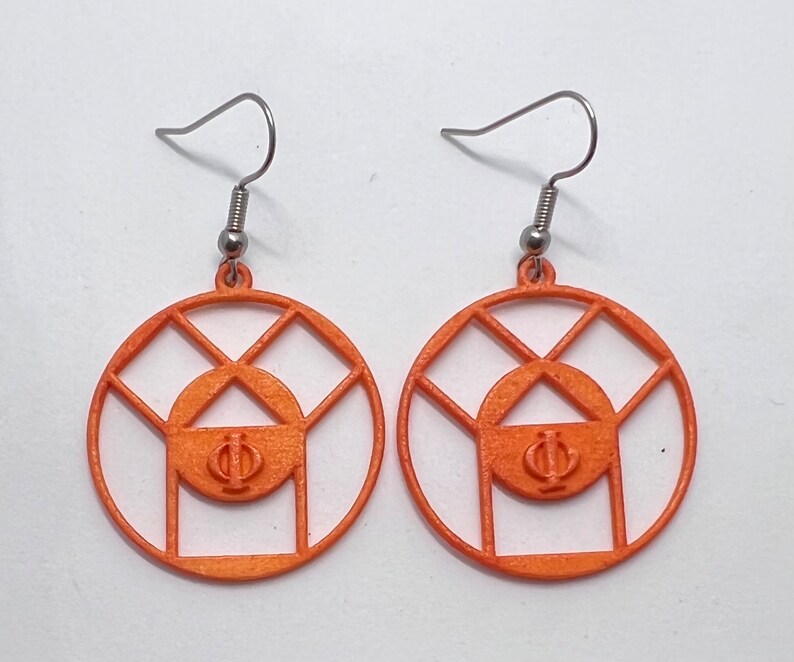 May include: A pair of orange earrings with a geometric design. The earrings are made of a thin, wire-like material and feature a circle with a smaller circle inside. The smaller circle has the Greek letters Phi and Psi inside.