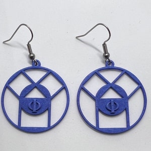 May include: A pair of blue earrings with a geometric design featuring a circle with a smaller circle inside and the Greek letter Phi in the center. The earrings are made of a lightweight material and have a silver hook.