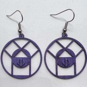 May include: A pair of purple earrings with a geometric design and a Greek letter Phi in the center. The earrings are made of metal and have a silver hook.