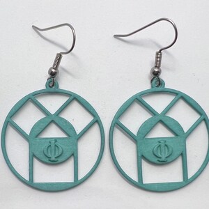 May include: A pair of teal blue earrings with a geometric design featuring a circle with a triangle inside and the Greek letter Phi. The earrings are made of metal and have silver hooks.