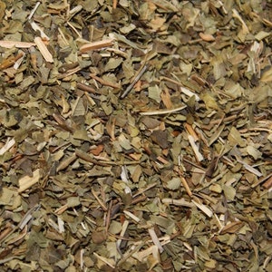 May include: Close-up of dried green and brown herbs, likely a blend for tea or cooking.