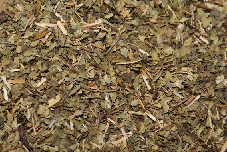 May include: Close-up of dried green and brown herbs, likely a blend for tea or cooking.