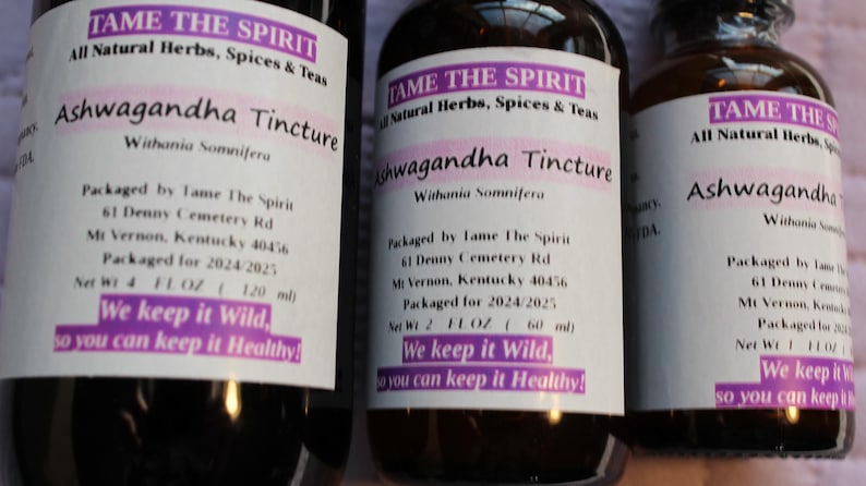 May include: Three glass bottles with brown liquid and white labels. The labels read "Tame The Spirit" and "Ashwagandha Tincture". The bottles are labeled with the ingredients, packaging information, and the text "We keep it wild, so you can keep it healthy!"