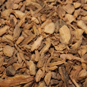 May include: Close-up of dried, brown, and tan pieces of ginger root.