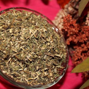 May include: A glass bowl filled with dried green herbs, likely for use in herbal teas or remedies.