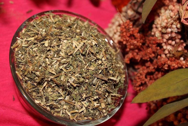 May include: A glass bowl filled with dried green herbs, likely for use in herbal teas or remedies.