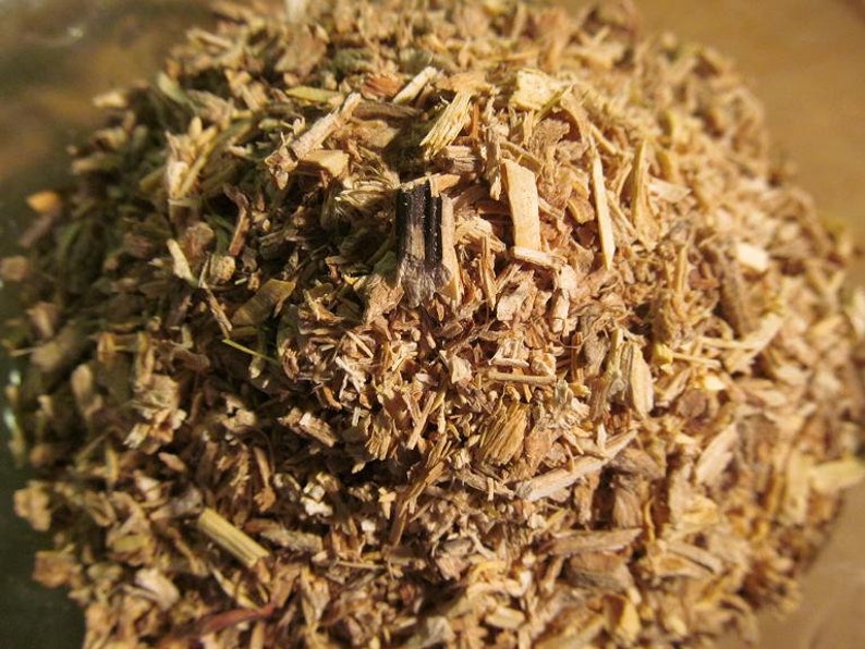May include: Close-up of a pile of dried, light brown, and tan herbal tea. The tea is made of finely chopped pieces of root and bark.