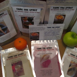 May include: Assortment of eight silver pouches containing various dried herbs and spices. The pouches are labeled with the brand name "Tame The Spirit" and the name of the herb or spice, such as "Peppermint Leaf", "Green Tea", "Moringa Leaf", "Chamomile", "Beet Root Powder", and "Devil's Claw".