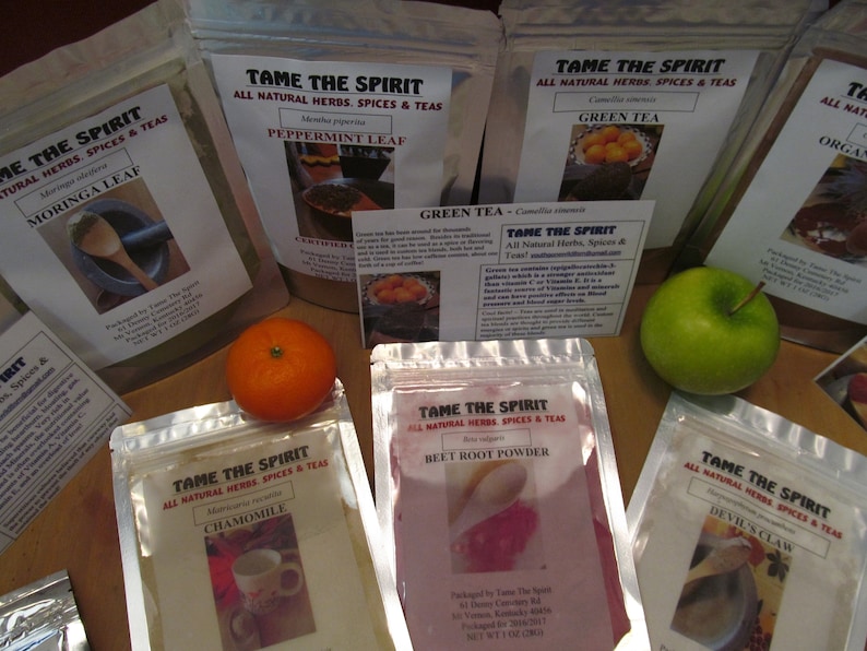 May include: Assortment of eight silver pouches containing various dried herbs and spices. The pouches are labeled with the brand name "Tame The Spirit" and the name of the herb or spice, such as "Peppermint Leaf", "Green Tea", "Moringa Leaf", "Chamomile", "Beet Root Powder", and "Devil's Claw".