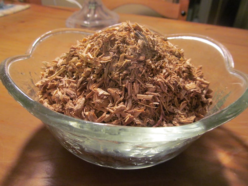 May include: A glass bowl filled with a large amount of light brown wood shavings.