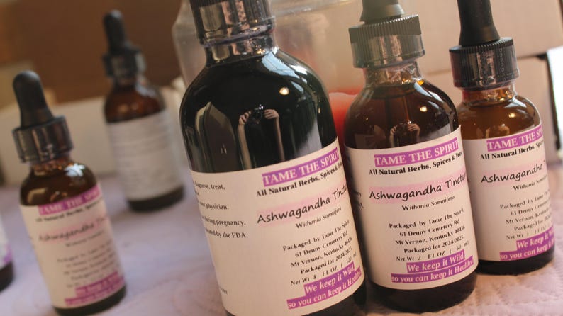 May include: Four glass bottles with dark liquid inside. The bottles are labeled "Tame the Spirit" and "Ashwagandha Tincture". The bottles are all natural herbs, spices, and tinctures. The bottles are packaged in Vermont, USA.