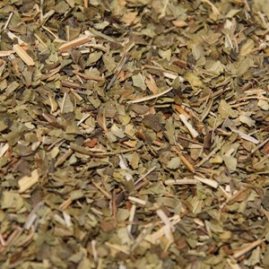 May include: Close-up of dried green and brown herbs, likely a blend for tea or cooking.