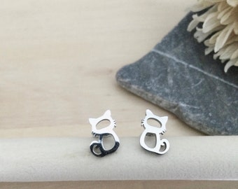 Peut inclure: Une paire de boucles d'oreilles clous en argent en forme de chat. Les boucles d'oreilles sont petites et délicates, et elles sont parfaites pour ajouter une touche de fantaisie à n'importe quelle tenue.