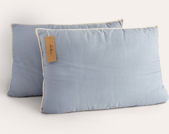May include: Two light blue pillow covers with a white trim. The pillow covers have a brown tag with the word "Lalba" written on it.