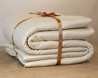 May include: A folded white silk duvet tied with a brown satin ribbon.