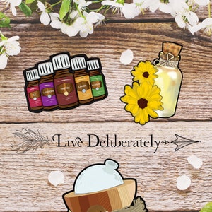 May include: An illustration of essential oil bottles labeled R.C., Lavender, Thieves, Lemon, and M-Grain. A glass bottle with a cork and sunflowers, and a wooden bowl with the word "Inhale" are also shown. The text "Live Deliberately" is also present.