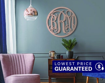 May include: A circular wall-mounted monogram sign featuring the letters BRM in a decorative, interconnected script font. The sign has a metallic rose gold finish and is displayed on a solid wall surface, showcasing intricate, swirling letter designs.